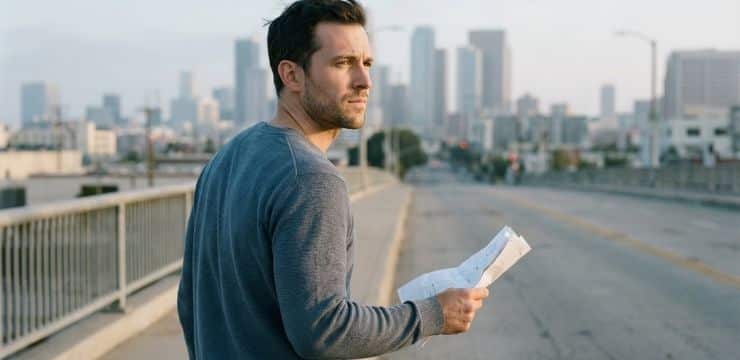 Build Your Content Engine Course creator pauses on city bridge reviewing outline after AI messaging disconnect