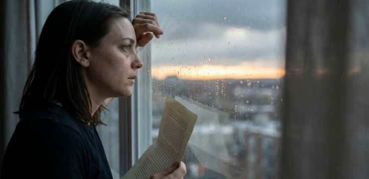 Find Your Inner Strength uplifting quotes concept, person by rain window at sunrise holding paper in quiet apartment